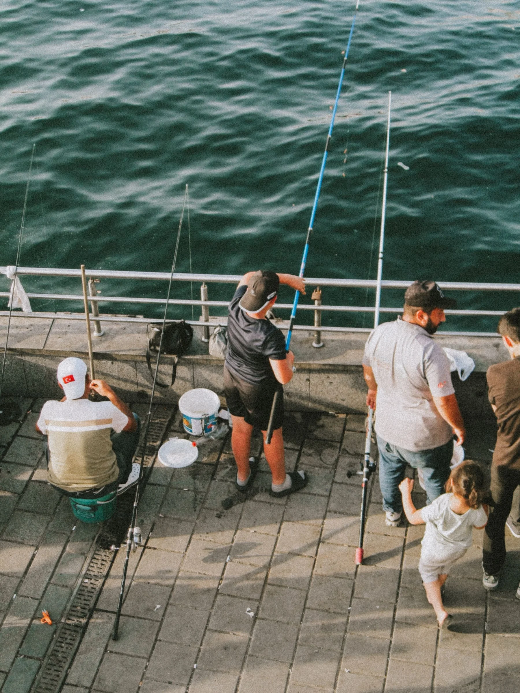 A group of anglers beside the water on a pier